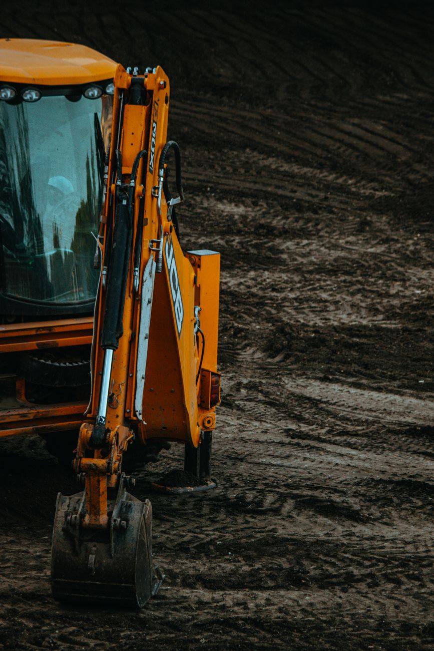 Excavator opening clay ground for septic repair work